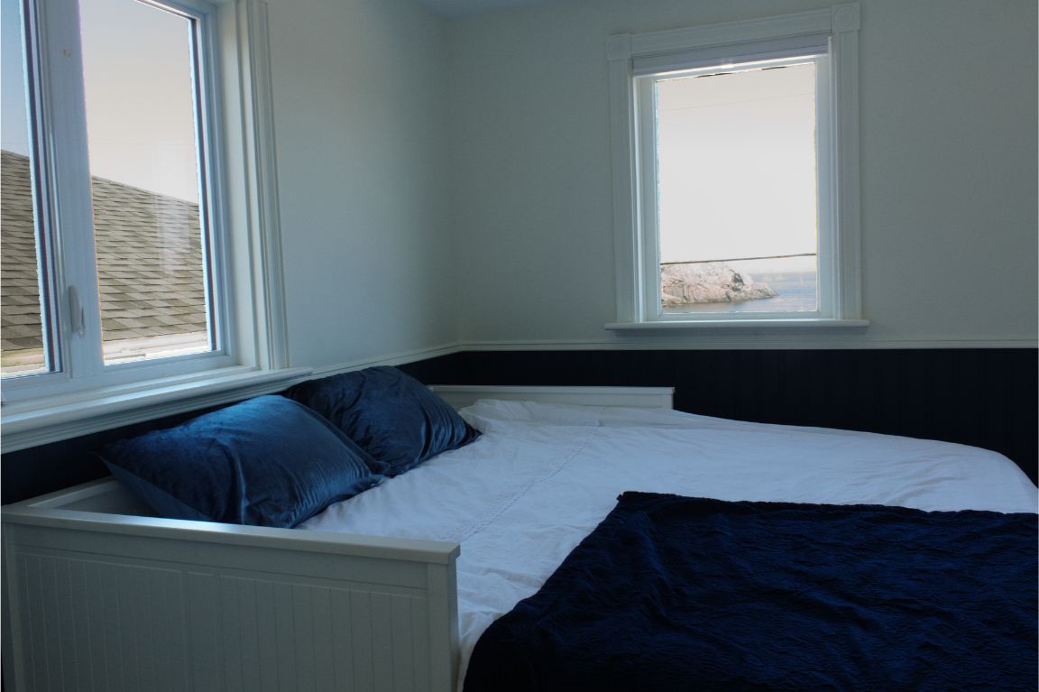 The Whale Room at the Archangel Studios residence — king bed, ocean-view desk, and large-screen TV.