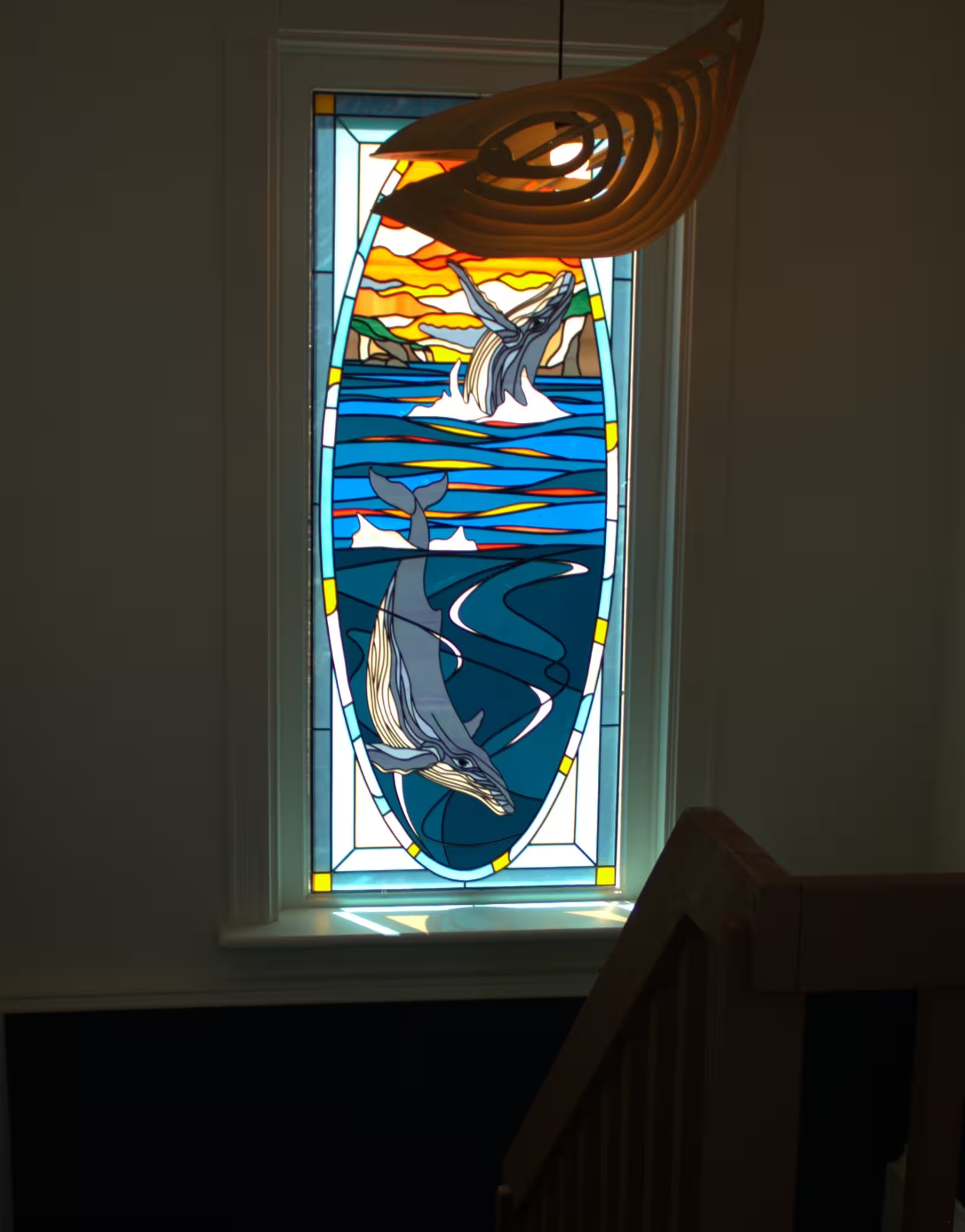 Stained glass window depicting humpback whales at the Archangel Studios residence.