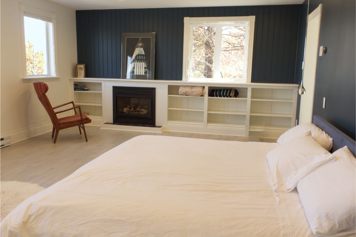 The master bedroom at the Archangel Studios residence, with a king bed and propane fireplace.